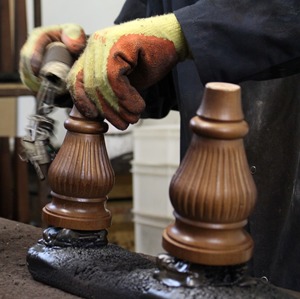 Tetrad furniture legs being hand finished by spraying